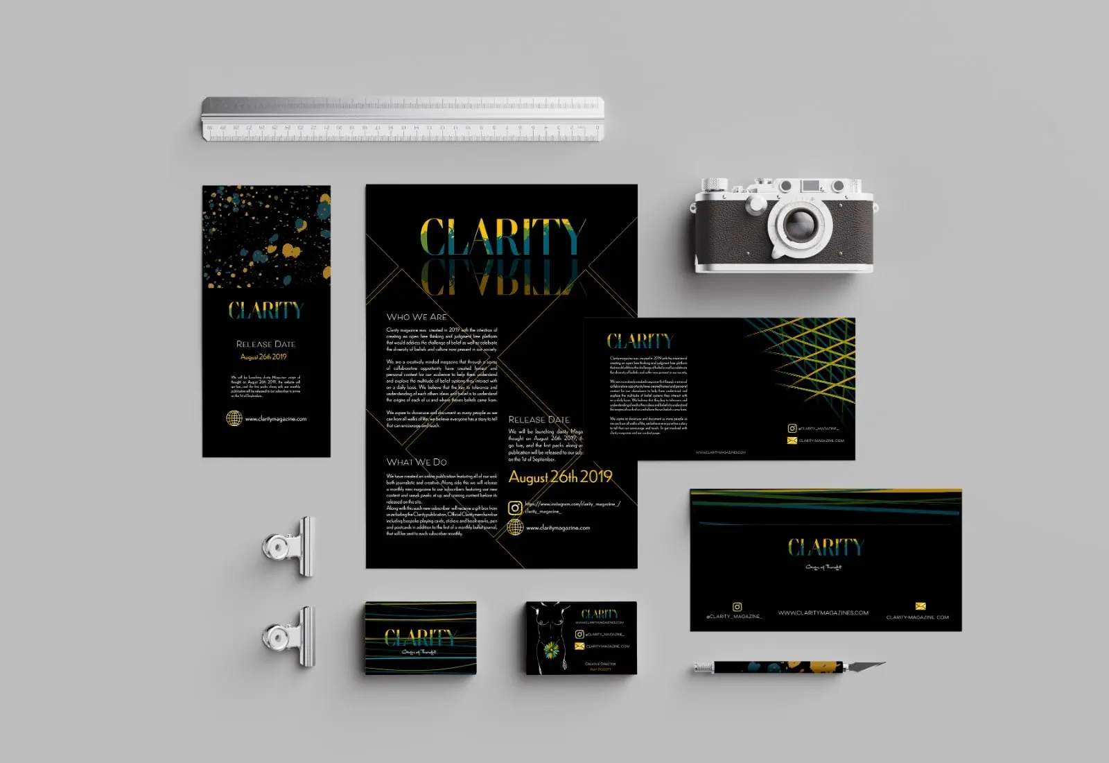 Clarity press pack laid flat: folder, letterhead, business cards and a camera